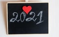 Handwritten by chalk number of New year 2021 with red Heart decoration. Hand drawn chalk lettering. Love