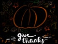 Handwritten Give Thanks sign with simple pumpkin and autumn leaves on black background.Stylish seasonal greeting card. Happy