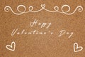 Handwritten happy valentine`s day lettering in white color on cork board