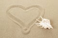 Handwritten heart on sand with seashell