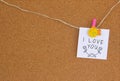 Handwritten I love you with flowers and hearth shape on white paper pinned with yellow fish mandala on cork board Royalty Free Stock Photo
