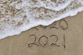 Handwritten inscription 2020 and 2021 on beautiful golden sand beach. Royalty Free Stock Photo