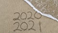 Handwritten inscription 2020 and 2021 on beautiful golden sand beach. Royalty Free Stock Photo