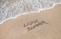 Handwritten inscription, letters, I Love Summer on the wet sand on the background of the sea wave washing away with water Royalty Free Stock Photo