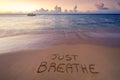 Handwritten Just breathe on sandy beach Royalty Free Stock Photo