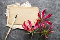 Handwritten letters and gloriosa flowers on grey stone background