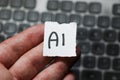 Handwritten note displaying the term AI, symbolizing artificial intelligence displayed in a close-up view against a blur Royalty Free Stock Photo