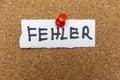 A handwritten note displaying the word Fehler, meaning mistake in German, pinned on a corkboard. This image conveys conc Royalty Free Stock Photo