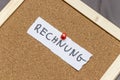 Handwritten note reading RECHNUNG pinned on a corkboard. The note highlights important information or reminders, providi Royalty Free Stock Photo