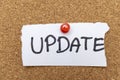 Handwritten note saying UPDATE pinned to corkboard with a red pushpin, emphasizing communication and keeping information Royalty Free Stock Photo