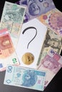 Handwritten question mark with bitcoin on it, banknotes around