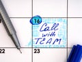 Handwritten reminder Call with Team in the calendar with a blue pen