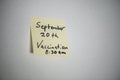 Handwritten sticky note on bulletin board to remember appointment date for vaccination