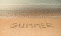 Handwritten summer on sand on the see beach. Word Summer. Vacation and holiday concept