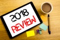 Handwritten text caption showing 2018 Review. Business concept writing for Feedback On Progress Written on tablet laptop, wooden b