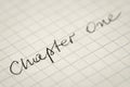 Handwritten text Chapter One on squared paper macro Royalty Free Stock Photo