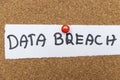 Handwritten text reading DATA BREACH pinned on a cork board, representing cybersecurity issues and data security concern Royalty Free Stock Photo