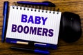 Handwritten text showing Baby Boomers. Business concept for Demographic Generation written on notebook book note paper on the wood Royalty Free Stock Photo