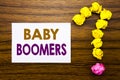 Handwritten text showing Baby Boomers. Business concept for Demographic Generation Written on sticky note paper, wooden background Royalty Free Stock Photo