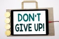 Handwritten text showing Don t Give Up. Business concept writing for Motivation Determination, Written on shopping bag and tablet