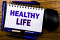 Handwritten text showing Healthy Life. Business concept for Good Health Food written on notebook book note paper on the wooden bac Royalty Free Stock Photo