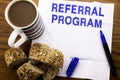 Handwritten text showing Referral Program. Business concept for Refer Marketing written on tissue paper on the wooden background