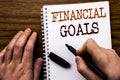 Handwritten text showing word Financial Goals. Business concept for Income Money Plan Written on tablet laptop, wooden background Royalty Free Stock Photo