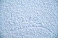 Handwritten underlined word `Love` is written on fluffy snow, on a frosty winter evening. Valentine`s Day.