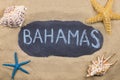 Handwritten word BAHAMAS written in chalk, among seashells and starfishes