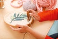 Handy needlewoman stitching beautiful ornament