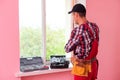 handyman adjusting white pvc plastic window indoors. worker using screwdriver to repair upvc window. homework