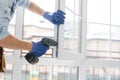 handyman adjusting white pvc plastic window indoors. worker using screwdriver to repair upvc window. homework