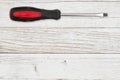 Handyman background with red and black screwdriver on distressed whitewash background