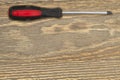 Handyman background with red and black screwdriver on distressed wood background