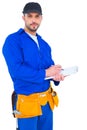 Handyman in blue overall writing on clipboard Royalty Free Stock Photo