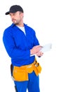 Handyman in blue overall writing on clipboard Royalty Free Stock Photo