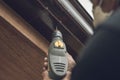 A handyman or carpenter drilling small rivet holes into the gutter of a roof. Using a power electric drill Royalty Free Stock Photo