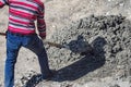 Handyman carries building mixture of cement and gravel with shovel. Repair and restoration of road. Royalty Free Stock Photo