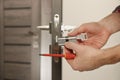 Handyman changing core of door lock indoors, closeup. Space for text Royalty Free Stock Photo