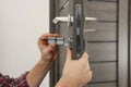 Handyman changing core of door lock indoors, closeup