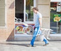 Handyman cleaning is walking down street with a ladder and bucket and cleaning tools