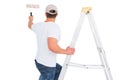 Handyman climbing ladder while using paint roller