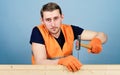 Handyman concept. Carpenter, woodworker on calm face hammering nail into wooden board. Man, handyman in working uniform Royalty Free Stock Photo