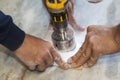 handyman cut round holes for electrical outlets in the marble countertop for the kitchen using a hand drill Royalty Free Stock Photo