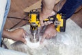 handyman cut round holes for electrical outlets in marble countertop for the kitchen using hand drill Royalty Free Stock Photo
