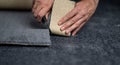 Handyman cutting a new carpet with a carpet cutter.