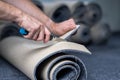 Handyman cutting a new carpet with a carpet cutter.