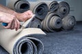 Handyman cutting a new carpet with a carpet cutter.