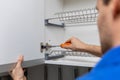 Handyman doing kitchen cabinet hinge adjustment Royalty Free Stock Photo