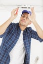 handyman fixate lamp on ceiling Royalty Free Stock Photo